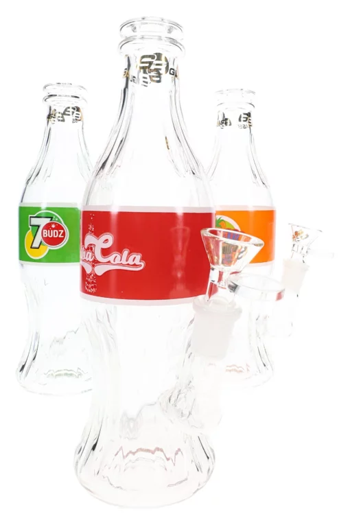 The Canna-Cola Mini Bubbler features three clear glass bottles styled after popular sodas, each modified with a glass bowl attachment and shown on a white background.