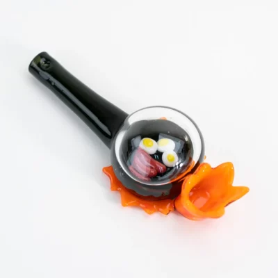 Empire Glassworks Sausage & Eggs Hand Pipe featuring a frying pan design with glass eggs and sausage under a clear dome lid, showcasing vibrant colors.
