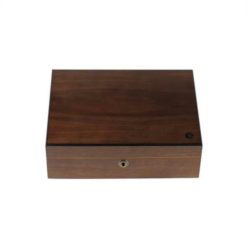 The HUMIDOR WALNUT COMBO BOX (8X11) is a closed rectangular wooden box with a smooth finish, a small keyhole on the front, and a subtle circular logo in the top right corner of the lid.