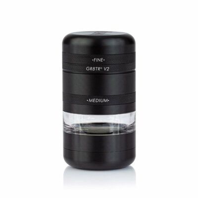 A black RYOT GR8TR Jar Body Grinder (V2) with FINE and MEDIUM sections, featuring a clear jar chamber to view contents, stands upright on a white background.