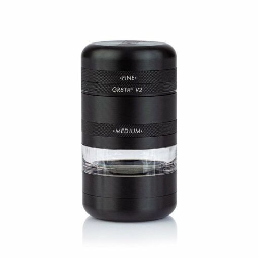 A black RYOT GR8TR Jar Body Grinder (V2) with FINE and MEDIUM sections, featuring a clear jar chamber to view contents, stands upright on a white background.