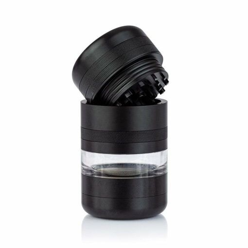 The RYOT GR8TR JAR BODY GRINDER, a black metal herb grinder with a clear window and jar body design, is shown open with its lid tilted to display sharp grinding teeth against a plain white background.