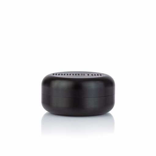A small, round, black RYOT GR8TR JAR BODY GRINDER with a smooth finish and "KANNASTOR" printed on the lid, shown against a white background.