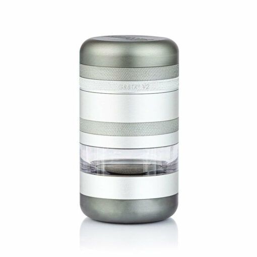 The RYOT GR8TR Jar Body Grinder features a metallic cylindrical design with textured grip bands, a transparent middle section, and a smooth matte finish, shown upright against a white background.