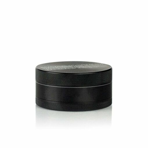 The RYOT 4PC SOLID BODY GRINDER, featuring a black cylindrical metal build with a textured surface and minimalist design, is displayed against a white background—highlighting its durability and everyday style.