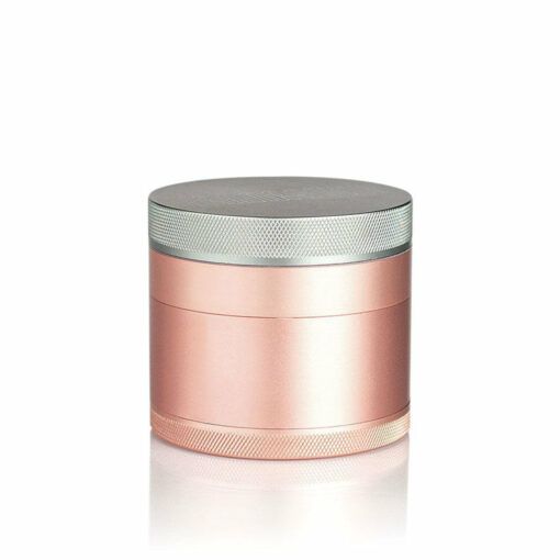 The RYOT 4PC SOLID BODY GRINDER is a rose gold and silver cylindrical metal grinder with a textured edge, displayed on a white background.