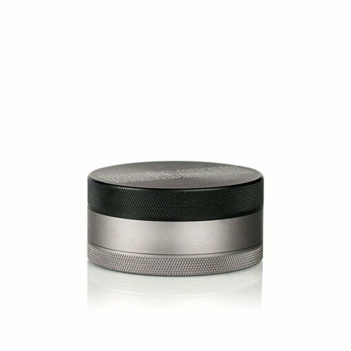The RYOT 4PC JAR BODY GRINDER is a metallic, cylindrical grinder with a textured grip, featuring a black top and silver bottom—ideal for fans of jar body grinders and RYOT’s renowned quality.