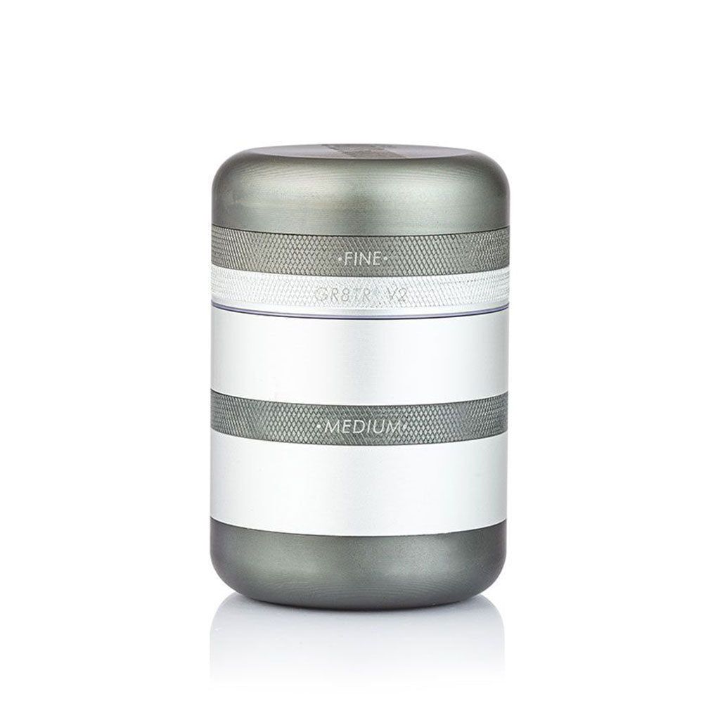 The RYOT GR8TR SOLID BODY GRINDER is a cylindrical metallic grinder featuring two labeled bands—FINE on the upper band and MEDIUM on the lower—shown against a white background.