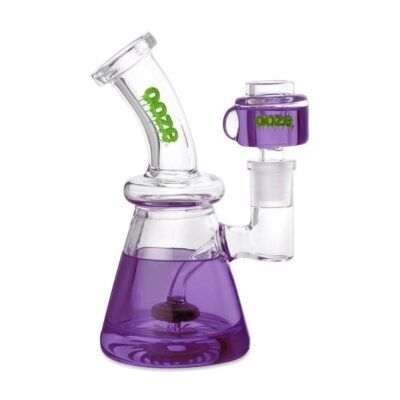 The Ooze Glyco Bong Glycerin Chilled Glass Water Pipe features a clear design with purple glycerin in the base, green Ooze branding, and a unique angled mouthpiece with a cylindrical side attachment for standout style.