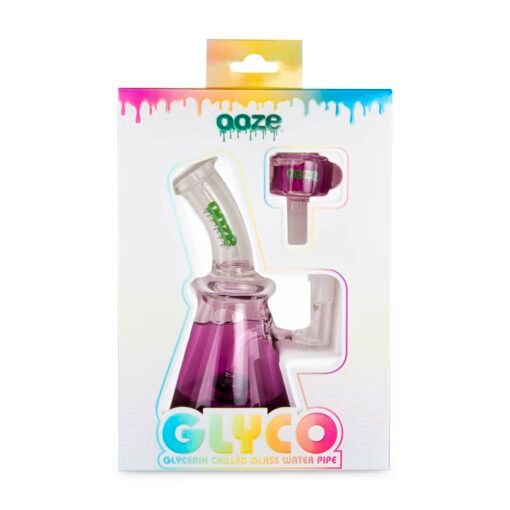 The Ooze Glyco Bong Glycerin Chilled Glass Water Pipe, in purple beaker shape, is boxed with a clear window and features colorful drippy designs on the top and bottom of the packaging.