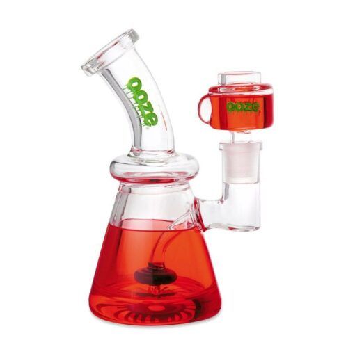 The Ooze Glyco Bong Glycerin Chilled Glass Water Pipe is a clear glass beaker with red liquid, an angled neck labeled "ooze" in green, and a side chamber filled with red liquid for smooth, chilled hits.