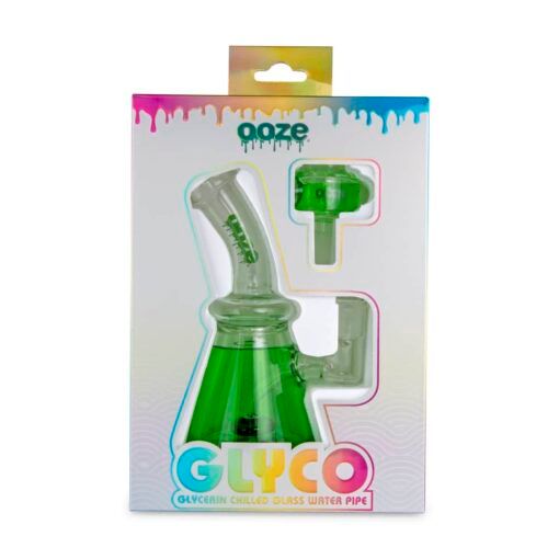 A boxed Ooze Glyco Bong Glycerin Chilled Glass Water Pipe with a green base, shown in clear packaging with colorful drips and branded graphics.