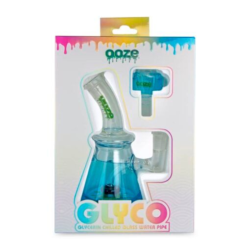 The Ooze Glyco Bong Glycerin Chilled Glass Water Pipe is packaged with a clear window, colorful drip designs, bold branding, and includes a blue glass water pipe with a matching attachment.