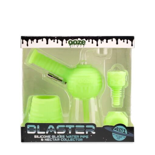 A boxed Ooze Blaster Silicone Glass 4-in-1 Hybrid Water Pipe and Dab Straw set, with neon green parts visible through clear packaging and black, blue, and white branding on the box.