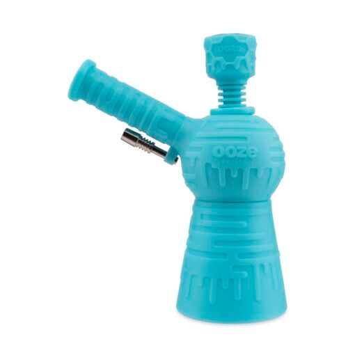 The Ooze Blaster Silicone Glass 4-in-1 Hybrid Water Pipe and Dab Straw is a bright blue piece with textured silicone, a cylindrical mouthpiece, round chamber, side removable bowl, and "ooze" embossed on the front.