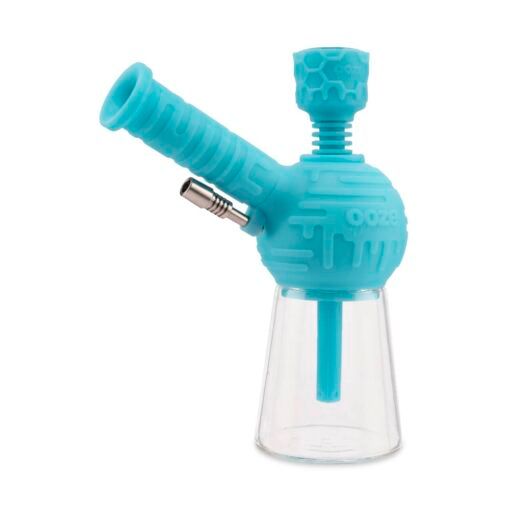 A blue Ooze Blaster Silicone Glass 4-in-1 Hybrid Water Pipe and Dab Straw with a clear round glass chamber, angled mouthpiece, metal bowl, textured silicone patterns, and “Ooze” branding.