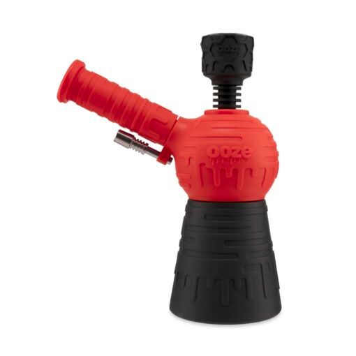 The Ooze Blaster Silicone Glass 4-in-1 Hybrid Water Pipe and Dab Straw features a red and black design with a round chamber, angled mouthpiece, sturdy base, drip-like patterns, and the ooze brand embossed on the side.