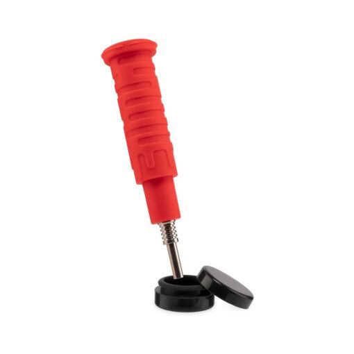 A red handheld coffee tamper with a textured grip and exposed metal spring is placed above two black round lids, resembling parts of the Ooze Blaster Silicone Glass 4-in-1 Hybrid Water Pipe and Dab Straw, set against a white background.