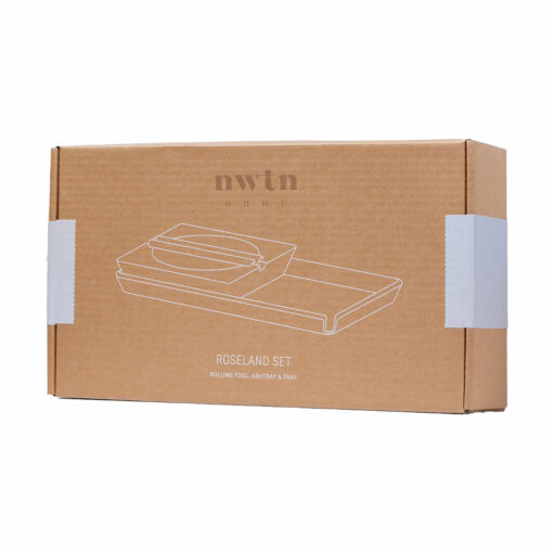 A brown cardboard box labeled NWTN Home contains a NWTN Home Roseland Set Ashtray, with outlined drawings of a rolling tool, ashtray, and tray on the front. White sealing tape secures both sides of the box.