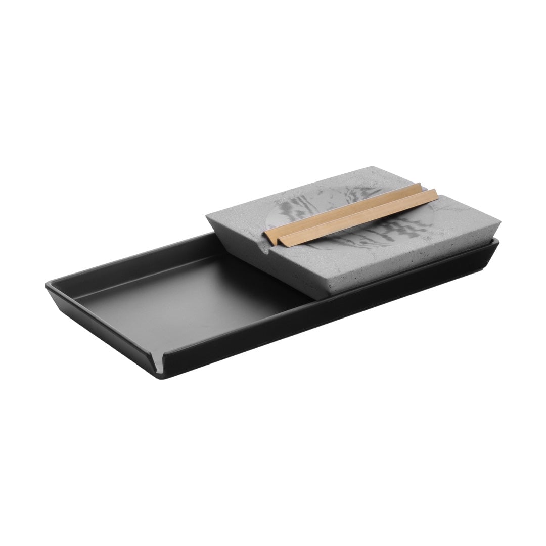 A rectangular black tray holds a slanted rectangular gray stone with a pool of water and a bamboo brush on top, resembling a traditional Japanese calligraphy water writing set—an elegant piece perfect as a Roseland Set or Home Ashtray.