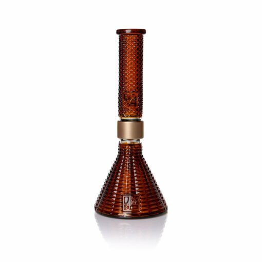 The Jane West x Prism Bong - Amber features a textured design with raised bumps, a cylindrical neck, conical base, and gold accent, highlighting the amber glass against a white background.