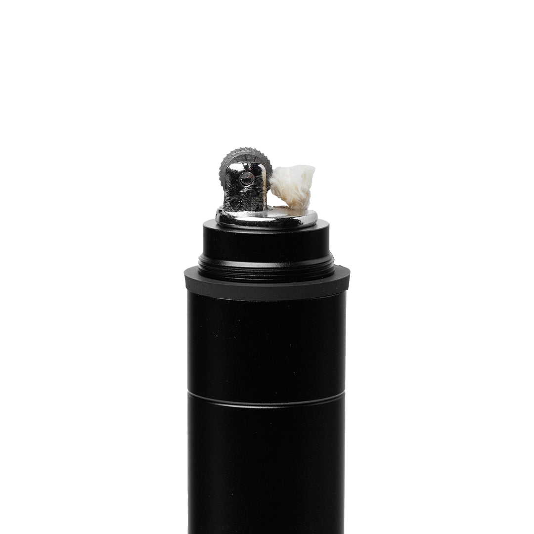 A close-up of a black electric shaver with its head open, showing internal blades and a small piece of tissue inside—an image echoing the precise engineering found in the Mj Arsenal Phoenix Baton—set against a white background.