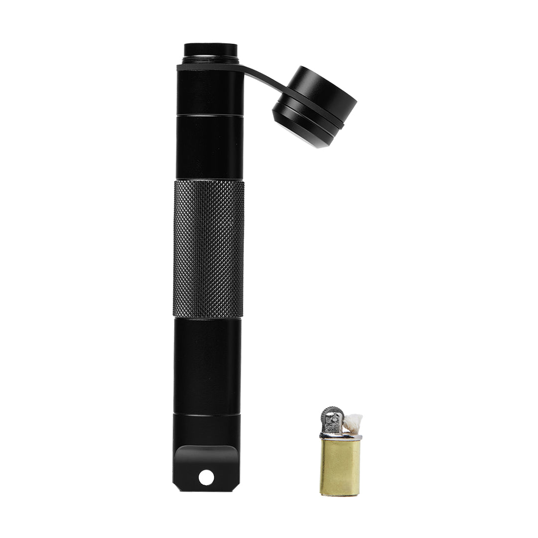 The Mj Arsenal Phoenix Baton, a black cylindrical tool with a textured grip and hinged cap, stands vertically next to a compact brass and silver lighter, both set against a white background.