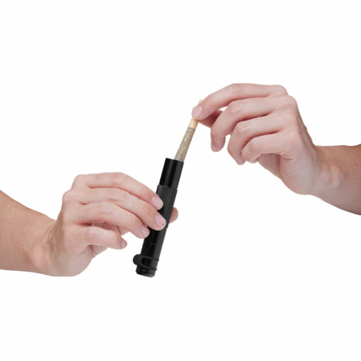 Two hands are shown; one holds the Mj Arsenal Phoenix Baton in black while the other places or removes a rolled joint from the container, set against a white background.