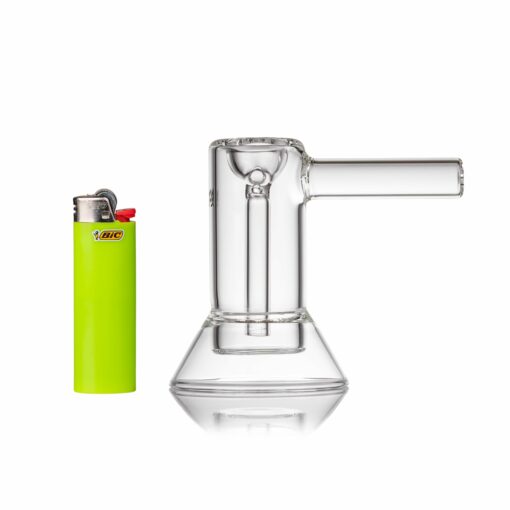 An MJ Arsenal Cove Glass Bubbler stands upright next to a bright green Bic lighter with a red button, both set against a white background.