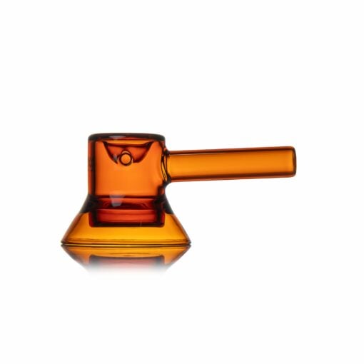 The MJ Arsenal Grotto Glass Pipe is a modern, amber glass pipe with a cylindrical mouthpiece and wide, stable base, shown on a white background with a subtle reflection.