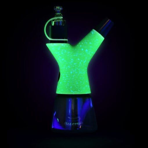 The Pulsar RöK Electric Dab Rig - Luna Glow is a Y-shaped glass water pipe with glowing green and blue sections, a speckled luminescent design, detachable bowl, and set against a sleek black background.
