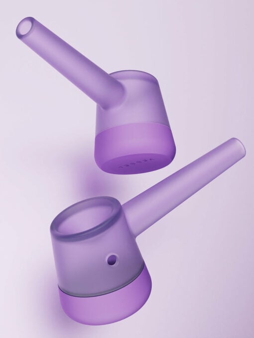 Two modern, translucent purple Forge [Lilac] vessels with long spouts and cylindrical bases are shown against a light purple background. They appear to be minimalist watering cans or pour-over vessels.