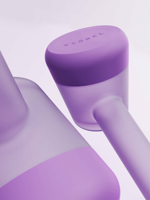 Close-up of two modern, cylindrical Forge [Lilac] containers in varying purple shades, with "VESSEL" embossed on one lid, set against a soft purple background. Ideal for making a stylish statement.
