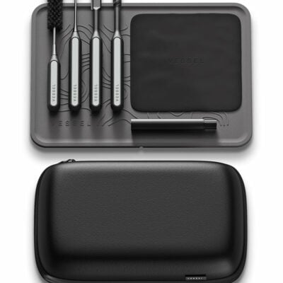The Care Kit includes a sleek black and gray tool set with five metal tools, a cleaning brush, and a VESSEL-labeled pad in a molded tray, all shown above its closed black zippered carrying case.