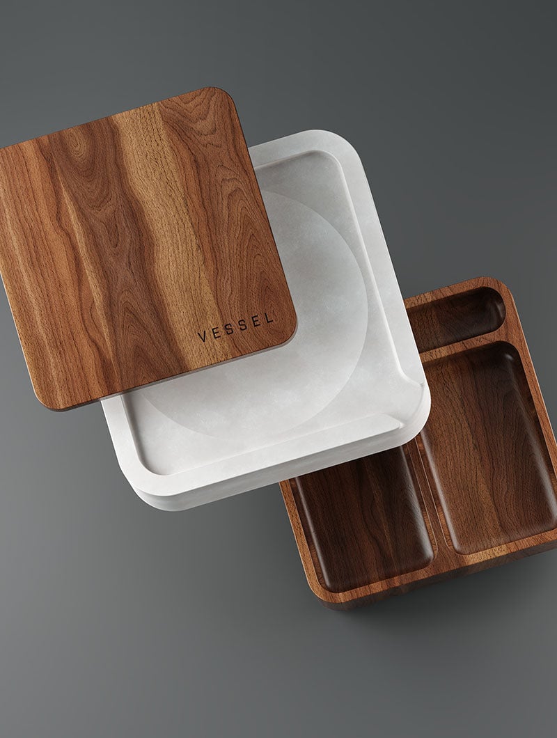 The Ash set includes a white square tray, a wooden lid engraved with VESSEL, and a two-compartment wooden tray, all showcased on a dark gray background with a sleek, modern look.