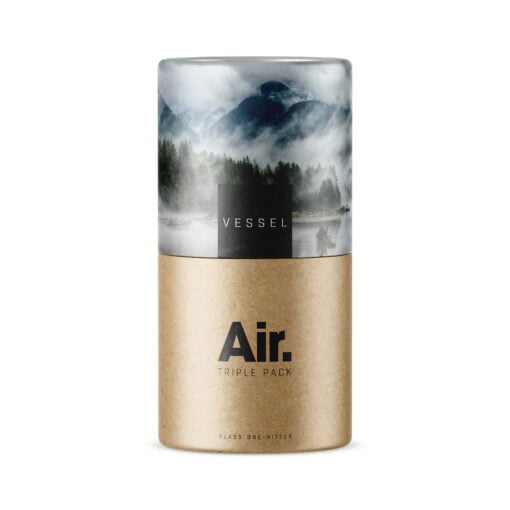 A cylindrical package featuring a scenic mountain and lake image on the upper half, kraft paper texture below. The text "VESSEL" appears on top with "Air [Gray] TRIPLE PACK" below.