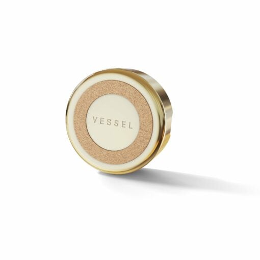 A small, round Ember [Gold] container with a metallic gold edge, cork accent, and VESSEL embossed on a cream center, photographed against a white background.