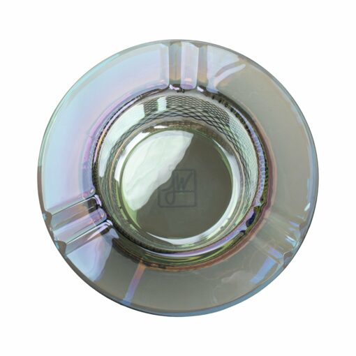 A round, iridescent glass ashtray from the Twenties Collection Ashtray | Mermaid, seen from above, with four cigarette grooves and a subtle etched logo or initials at the center.