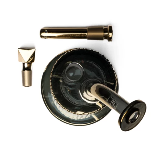 Top-down view of the Twenties Collection Water Pipe | Gold, a modern dark glass piece with gold metal accessories, including the pipe, mouthpiece, and gold attachment, displayed on a white background.