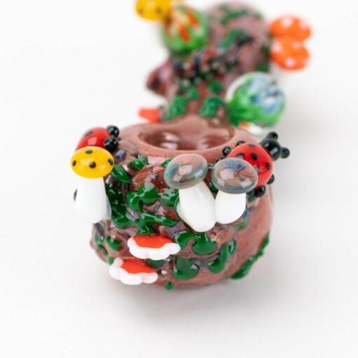 The Empire Glassworks Bug's Life Small Spoon Pipe features colorful, handcrafted glass mushrooms, ladybugs, and greenery near the bowl for a whimsical, Bug's Life-inspired appearance.