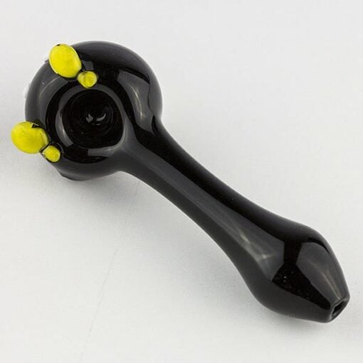 The Empire Glassworks Bomber Spoon Pipe is a black glass spoon with a round bowl and three yellow decorative bumps on the side, shown on a plain white background.