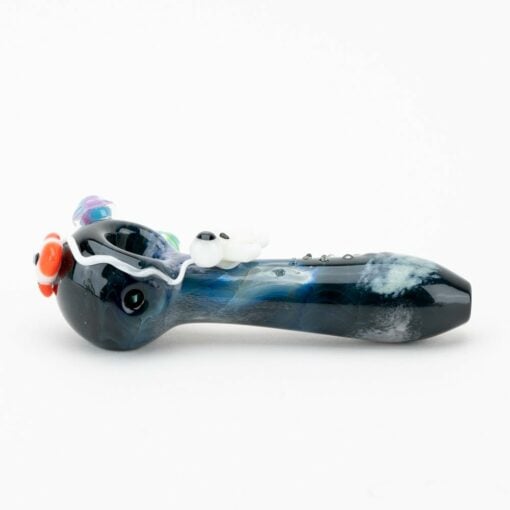 The Empire Glassworks Galactic Spoon Pipe is a blue and black glass pipe with a colorful flower by the bowl and raised white and black accents along the stem, displayed on a plain white background.