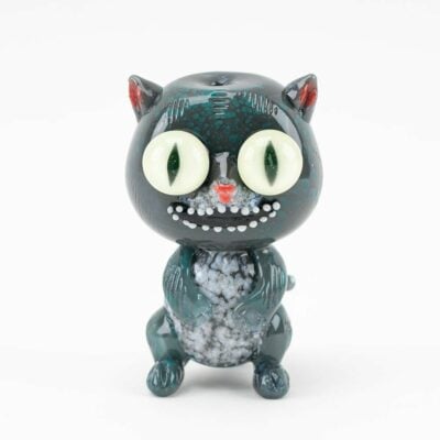 The Empire Glassworks Galacticat Dry Pipe features a small, stylized cat figurine with large round eyes, a black and gray body, red-tipped ears, and a textured white chest standing upright against a plain white background.