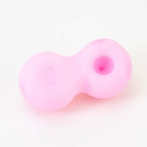 The Empire Glassworks Boobies Dry Pipe is a small, pink silicone figure-eight shaped piece with a round indented hole on one side, displayed on a white background.