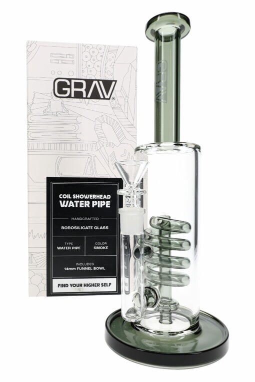 The GRAV Smoke Coil Showerhead Bong – 12.25″ features a clear glass body, smoke coil design, and smoky gray-tinted base and mouthpiece. It stands in front of packaging with technical illustrations and the GRAV logo for a stylish display.