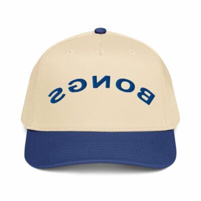The 5 panel cap SGNOB is beige with a blue bill and features "SGNOB" embroidered upside down in blue letters on the front.