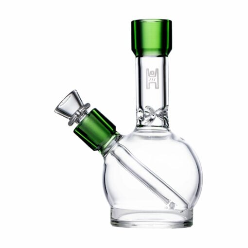 The Human Grade 6" Ball Water Pipe is a small, clear glass piece with green accents on the mouthpiece and bowl, featuring a round base and angled downstem. Crafted from human grade materials, it’s shown against a white background.
