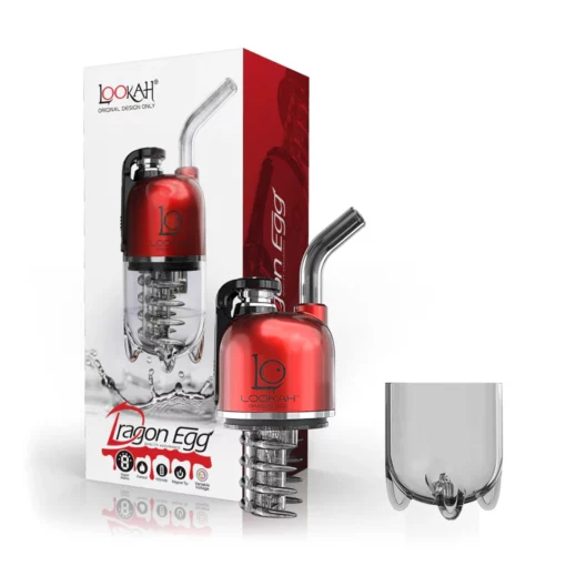 A Spatter Black-Green Lookah Dragon Egg Vaporizer is shown beside its packaging and a clear glass cup. The box displays the product image, brand logo, and features on a vibrant red and white background.