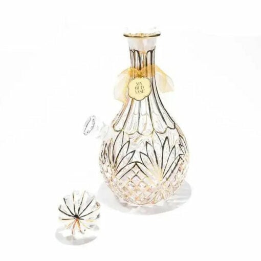 The Stardust Vase Bong is a crystal decanter featuring intricate cut patterns and a gold tag, shown with its matching stopper on a white background.