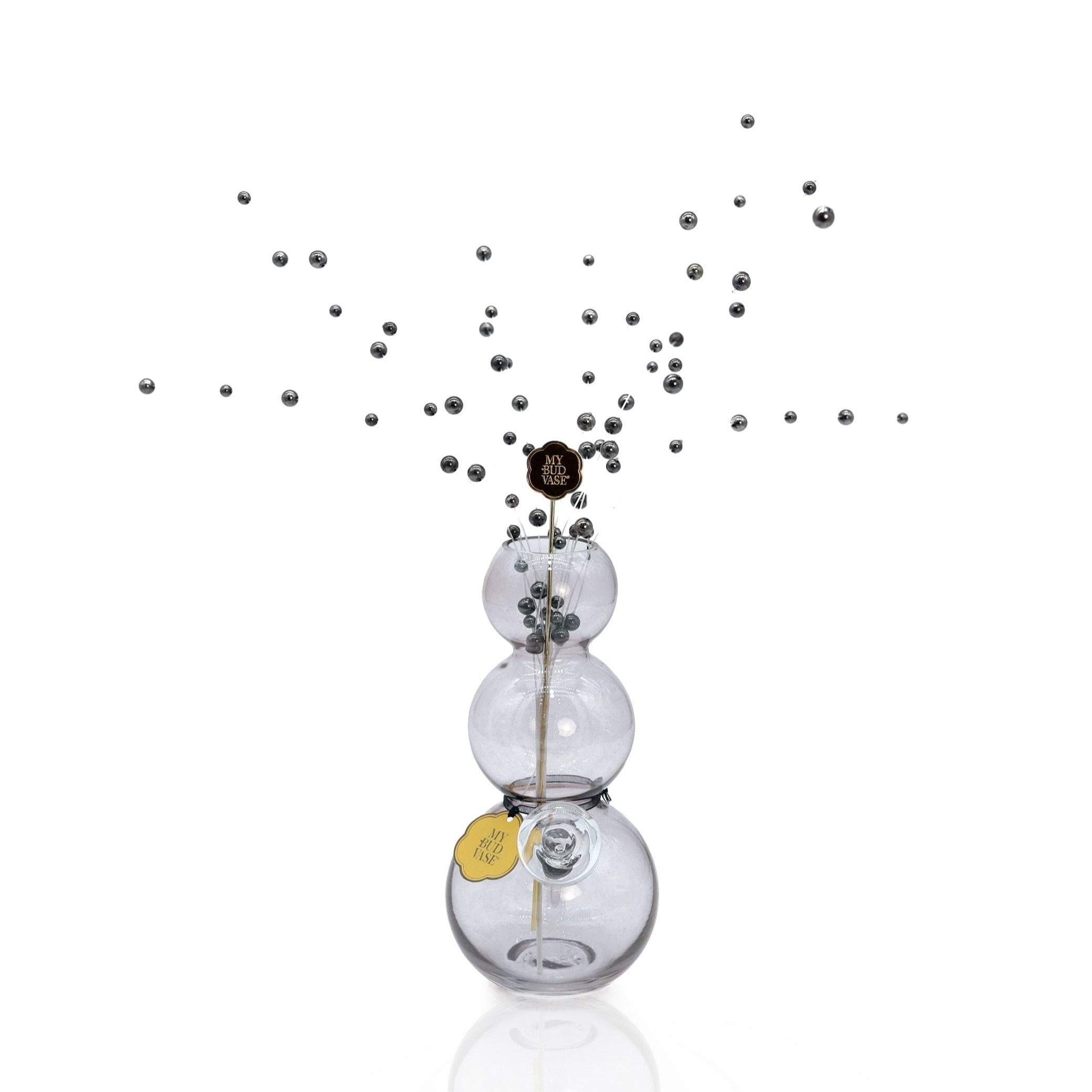 The Bubbles Vase Bong features three stacked glass orbs with a slim stick through the center, accented by floating silver beads and set against a white background.